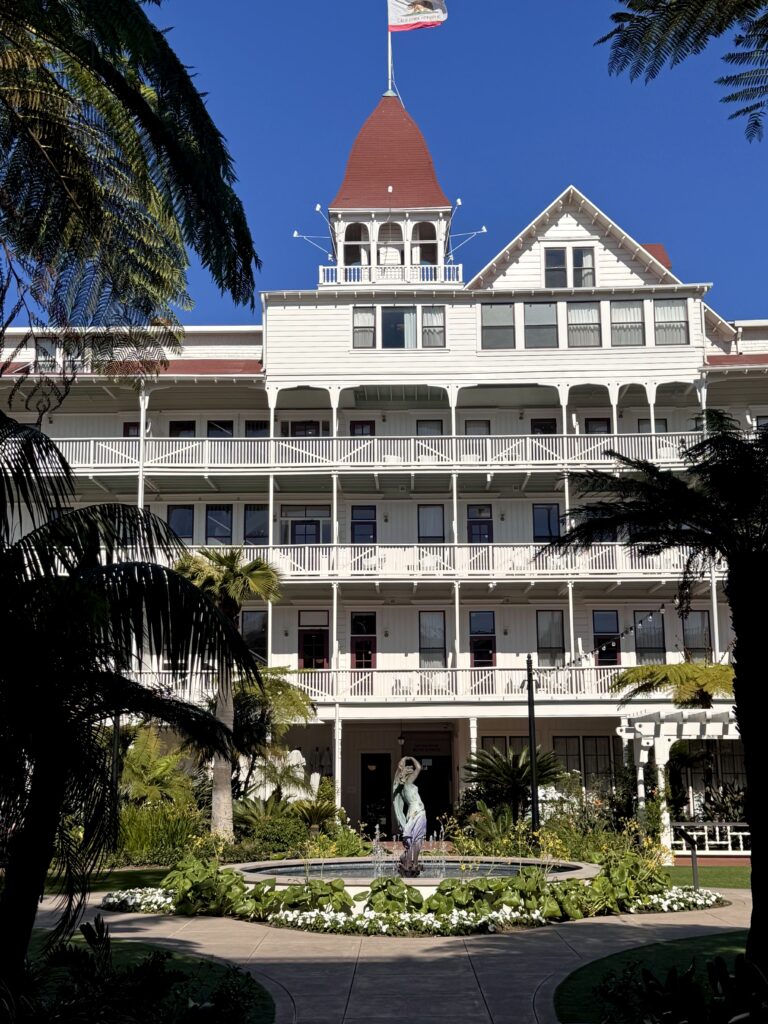 Hotel Coronado Courtyard, white building with red roof and statue.