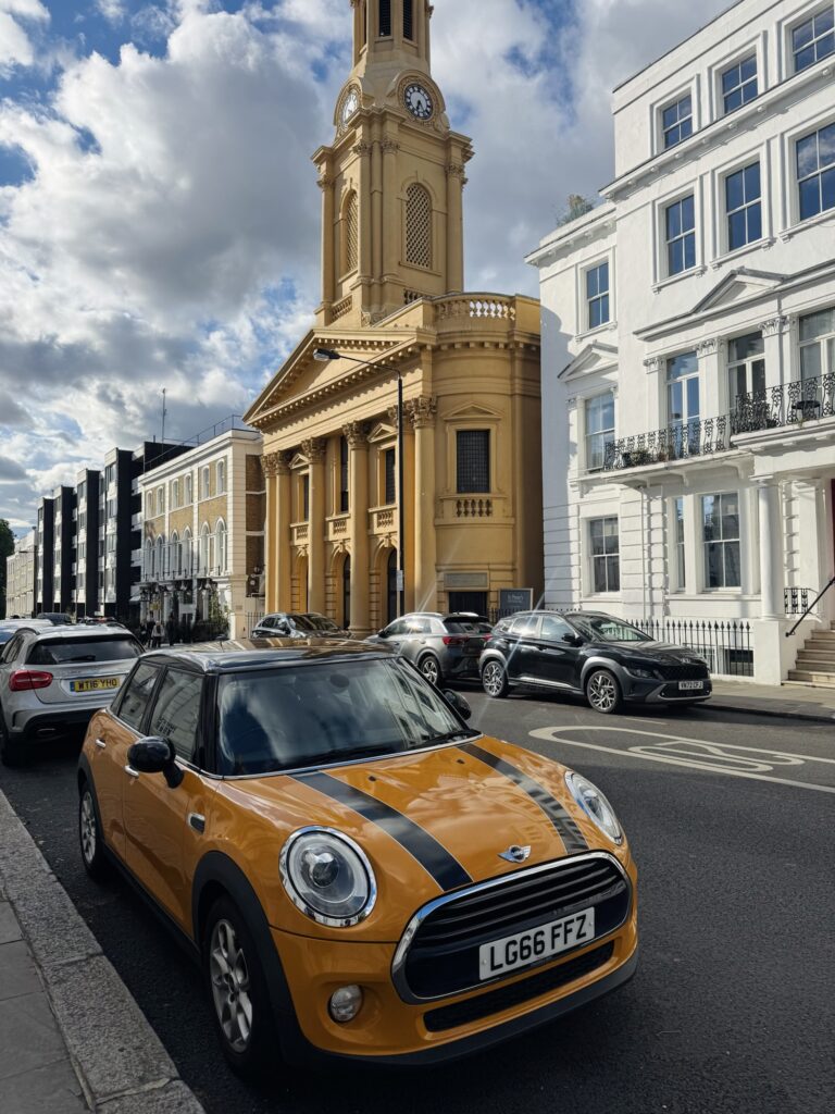 Cute yellow car in front of yellow building in Notting Hill