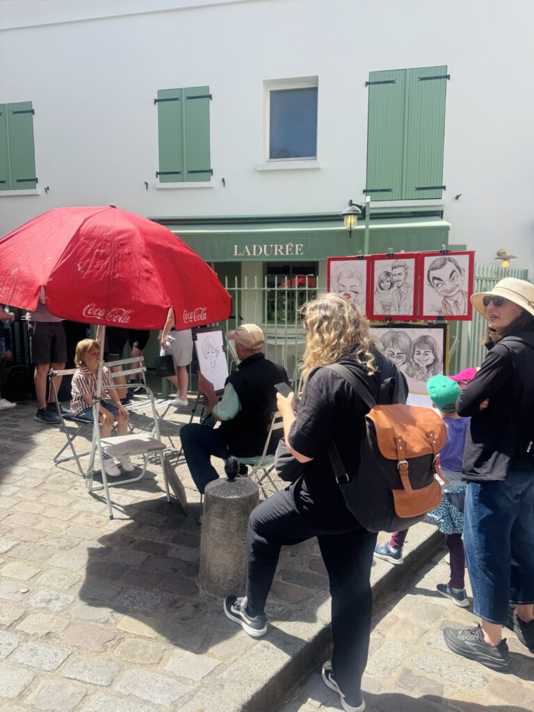 Caricature artist drawing young boy in Place du Tertre
