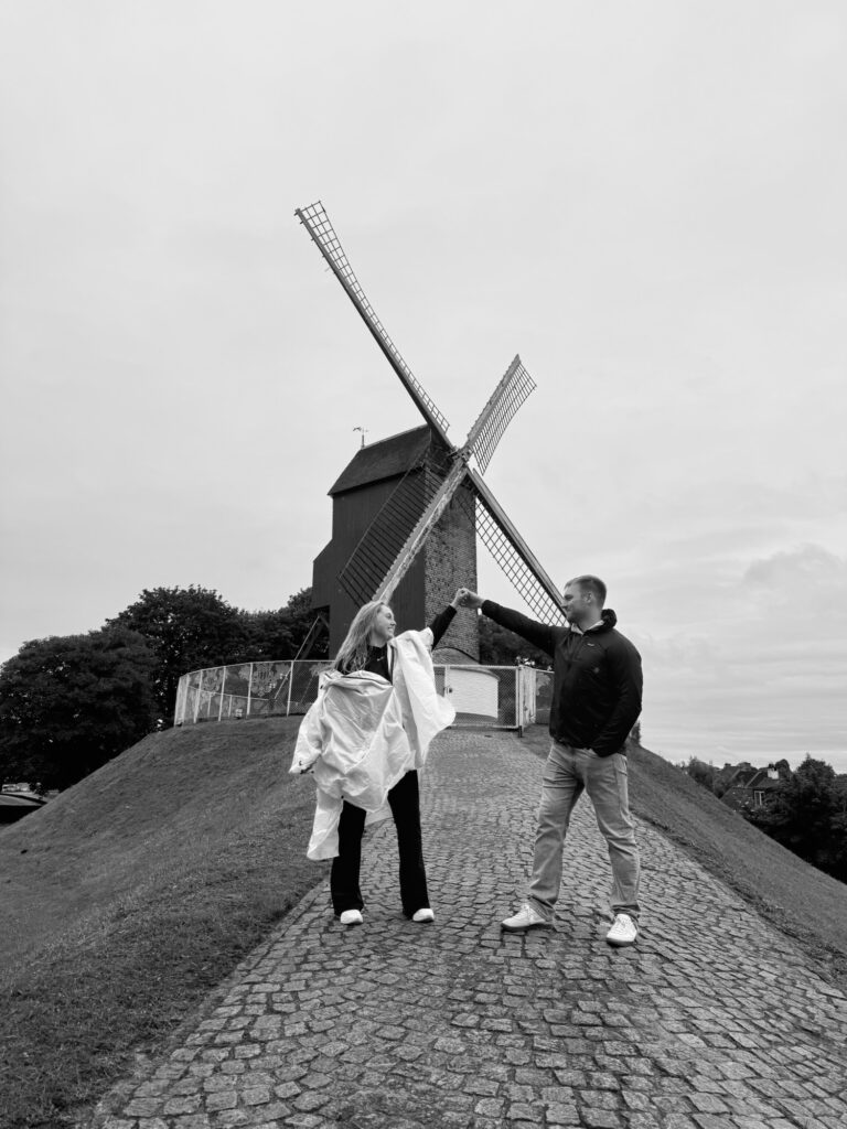 Couple in front of windmill in Bruges