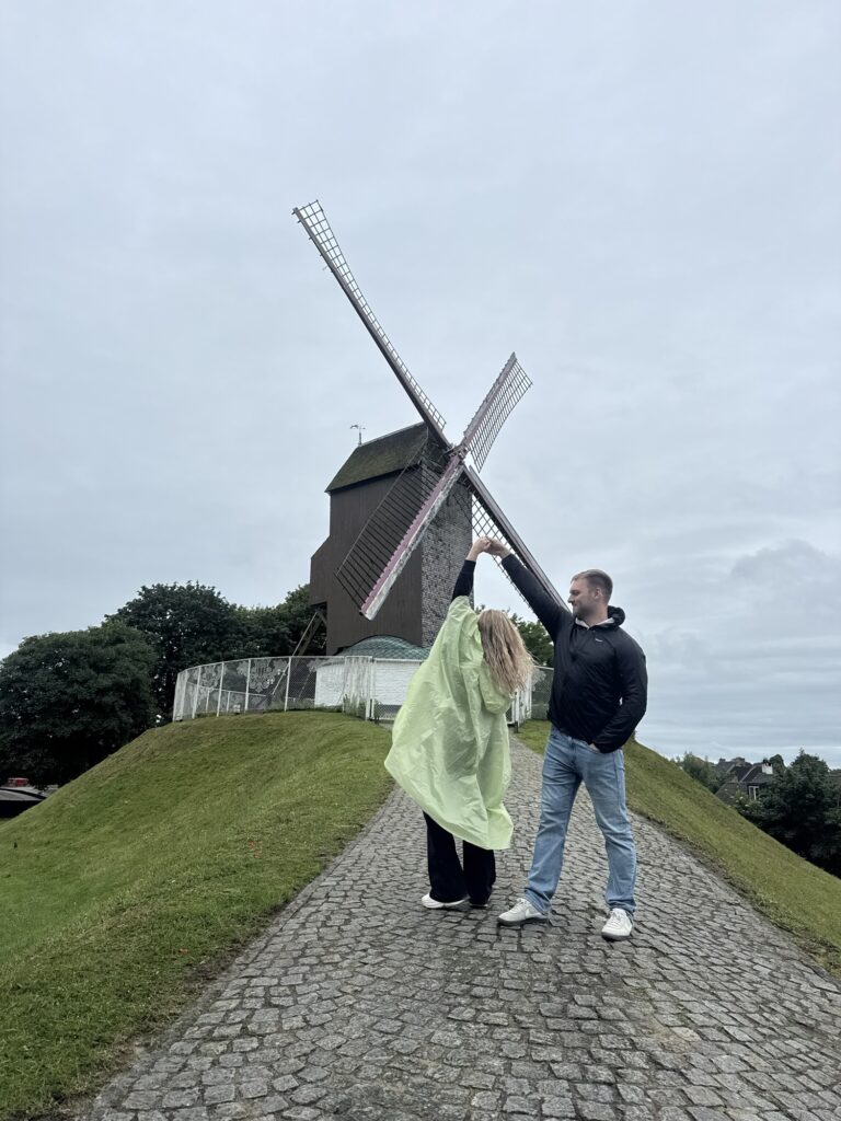 Couple in front of windmill in Bruges