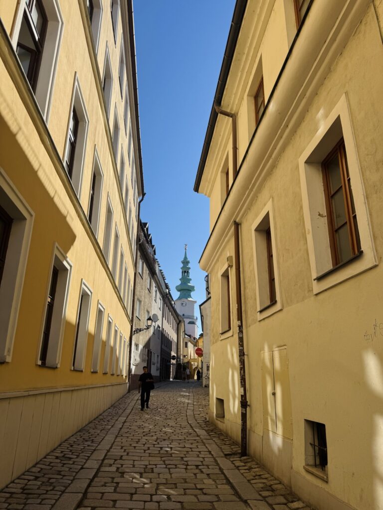 Yellow building brick street with St Michael's gate in the background
