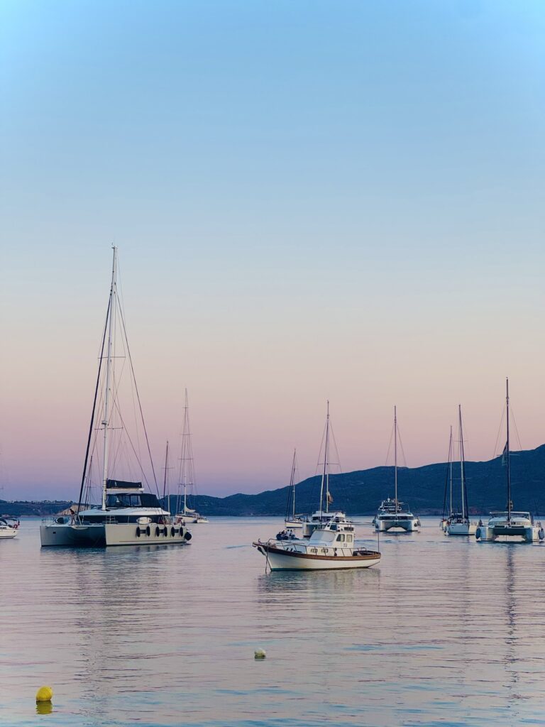 Sunset over Aegean Sea with sailboats in the bay