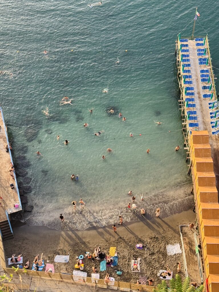 People swimming at spiaggia di San Francesco in Sorrento during the evening