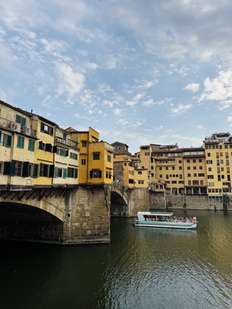 River Arno in Florence Italy with boat and buildings over bridge