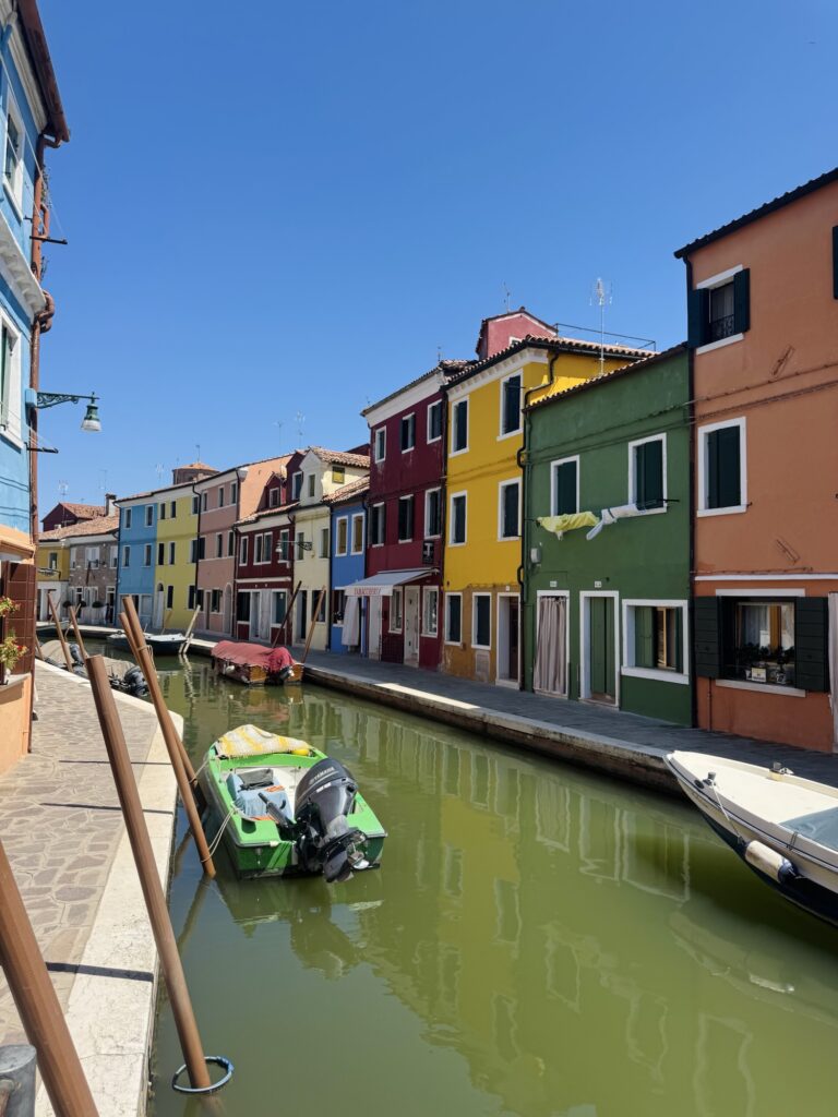 Colorful houses along canal in the quaint village of Burano in Italy