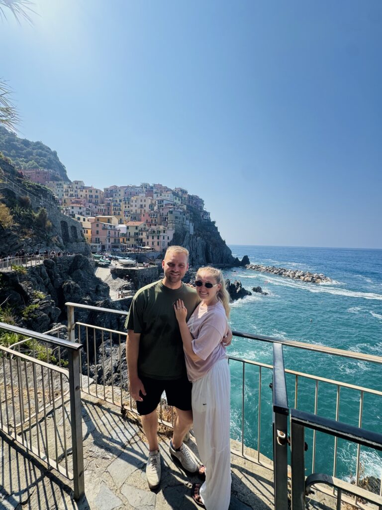 Couple smiling in front of Manarola village