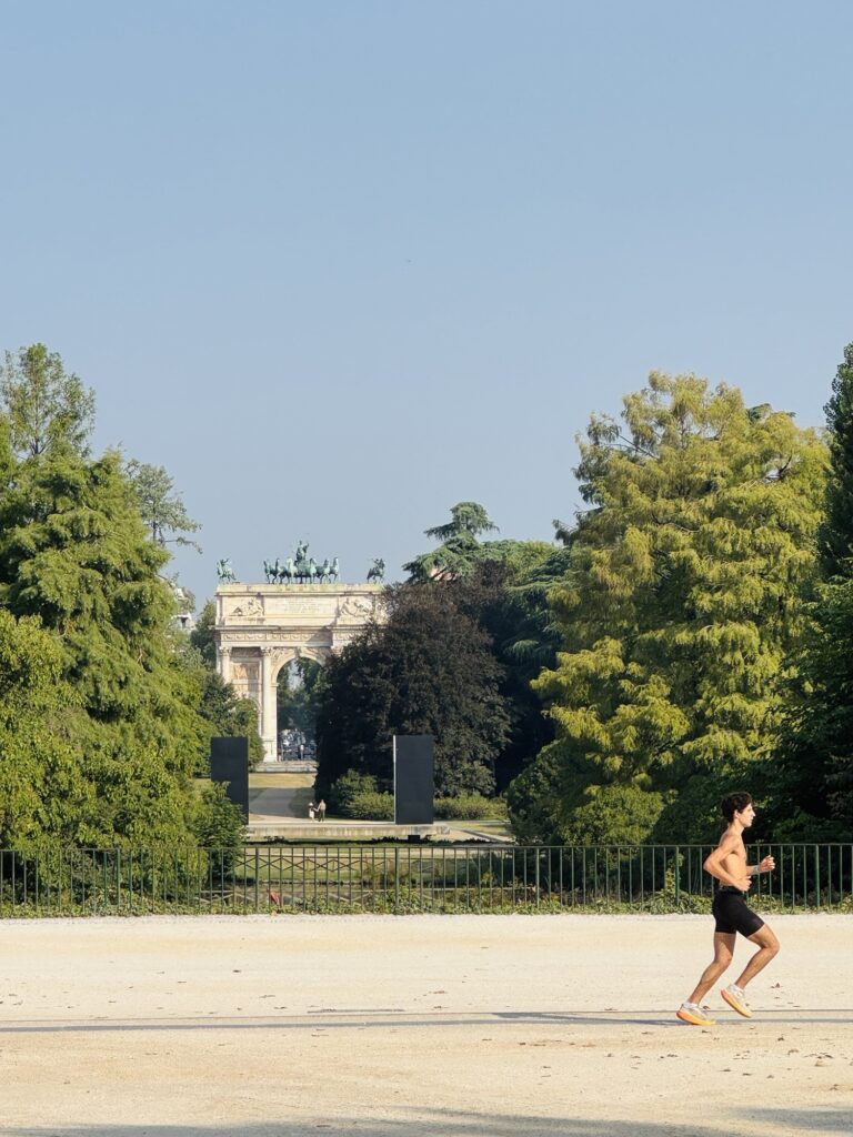 Runner in Parco Sempione with Arco della Pace in the background